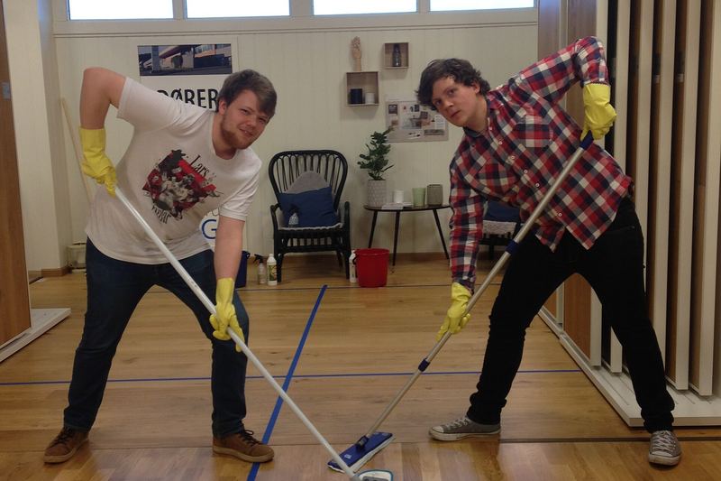 Two workers washing a floor with professional equipment